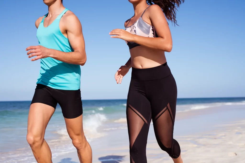 torso shot of a young couple running on a sandy wh utc